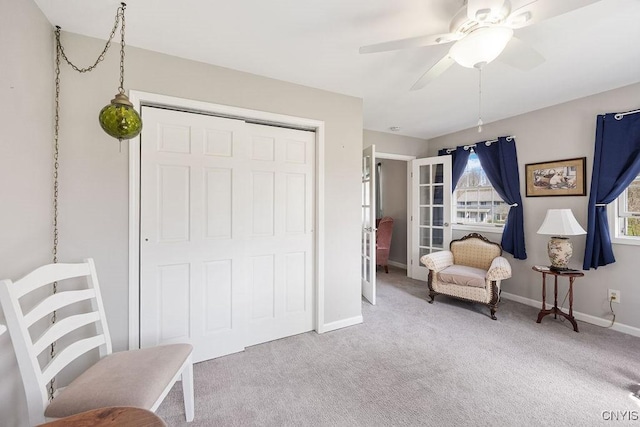 living area featuring carpet floors, ceiling fan, and baseboards
