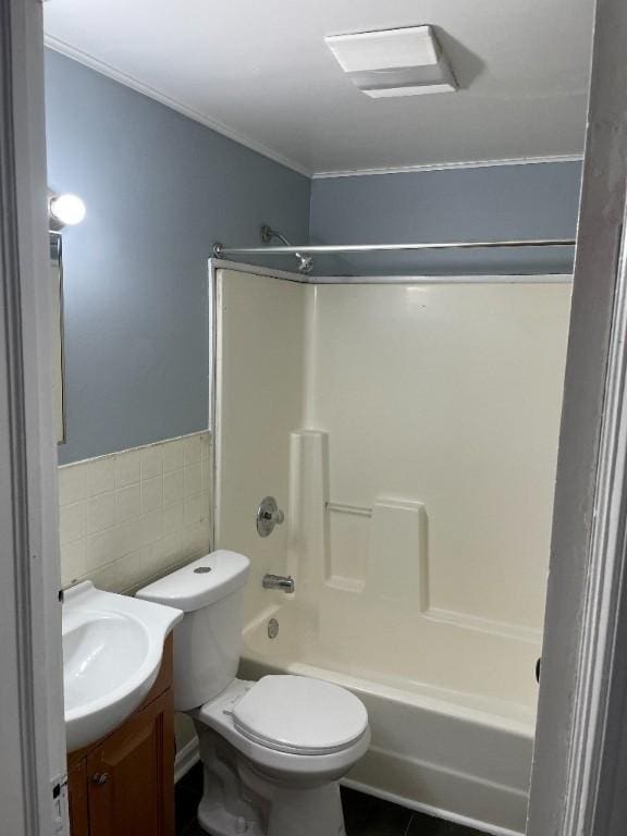 full bathroom featuring shower / bathing tub combination, tile walls, wainscoting, vanity, and toilet