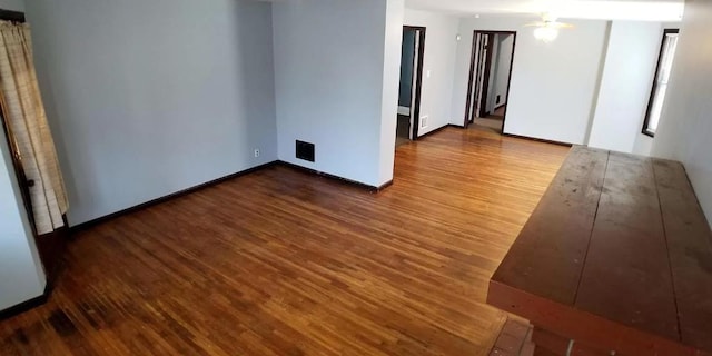 unfurnished room with baseboards and wood finished floors
