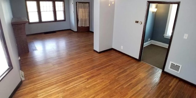 unfurnished room featuring baseboards, light wood finished floors, and visible vents