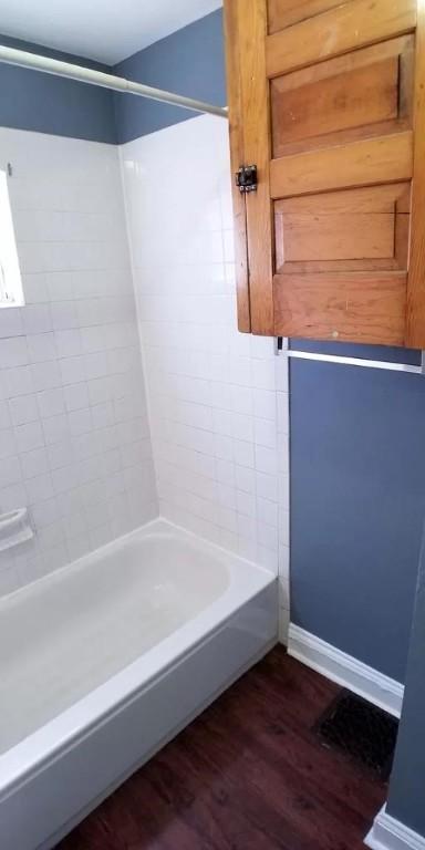 full bathroom featuring baseboards, shower / bathing tub combination, and wood finished floors