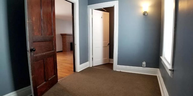 hall featuring baseboards and carpet