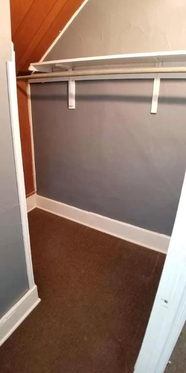 walk in closet with dark carpet