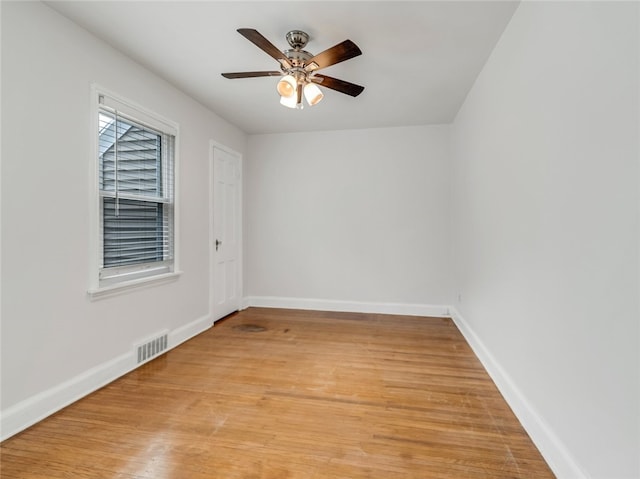 empty room with baseboards, visible vents, ceiling fan, and light wood finished floors