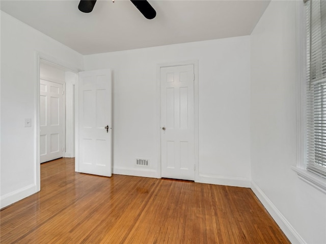 unfurnished bedroom with baseboards, visible vents, ceiling fan, and light wood finished floors