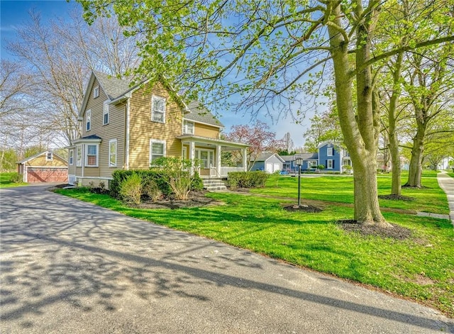 victorian home featuring an outbuilding, a porch, and a front lawn