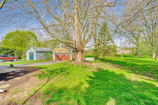 view of yard with a detached garage and an outdoor structure