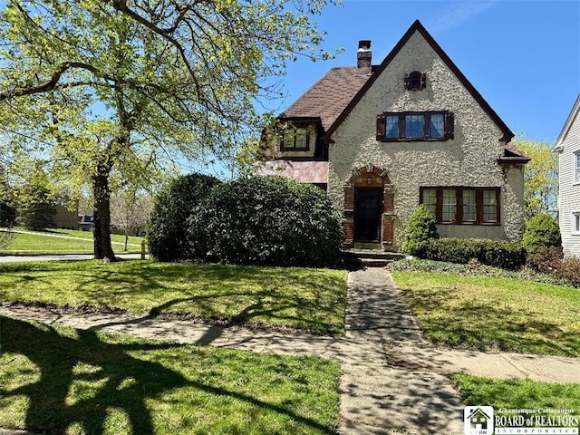 148 Myrtle St, Jamestown, NY 14701 - tudor house with stucco siding, a chimney, and a front yard