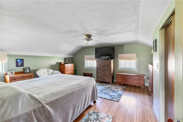 bedroom with wood-type flooring, baseboards, ceiling fan, and lofted ceiling