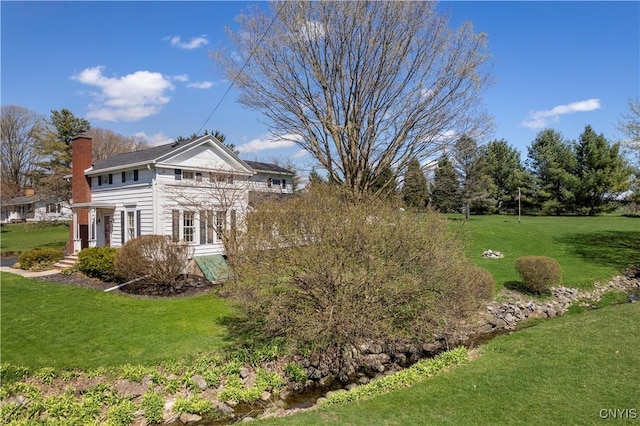 exterior space with a lawn and a chimney