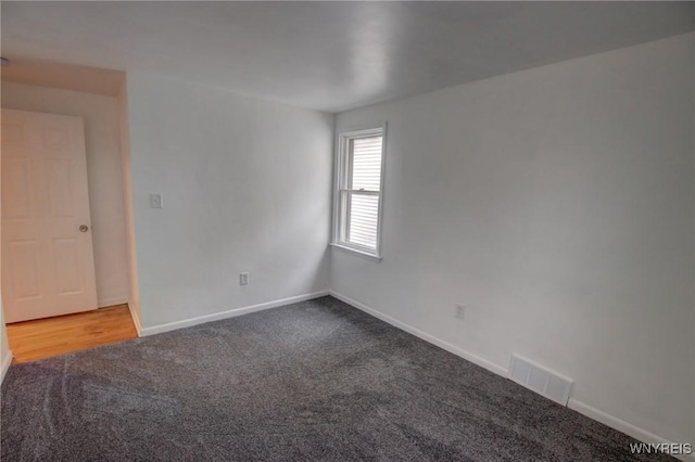 carpeted empty room with visible vents and baseboards