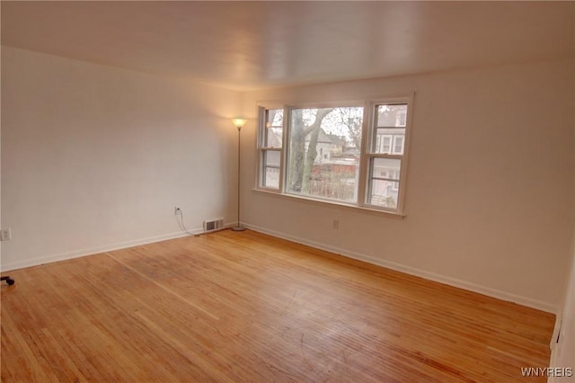 spare room with visible vents, baseboards, and light wood-type flooring