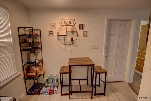 dining area with light wood-type flooring and baseboards
