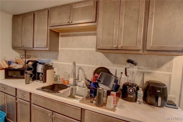 kitchen featuring a sink, tasteful backsplash, and light countertops