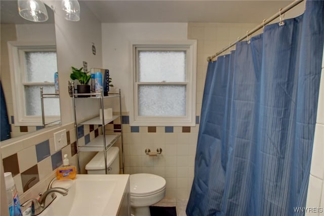 bathroom featuring vanity, curtained shower, toilet, and tile walls