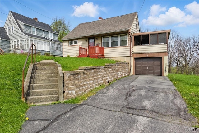 view of front of house featuring an attached garage, driveway, and a front lawn