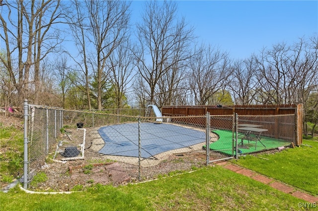 view of swimming pool featuring fence and a water slide