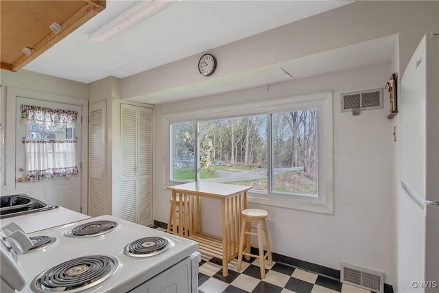 kitchen with tile patterned floors, white appliances, and visible vents