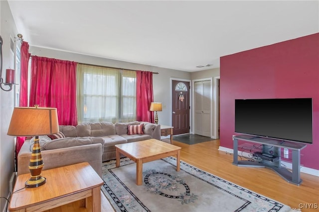 living room with baseboards, wood finished floors, and visible vents
