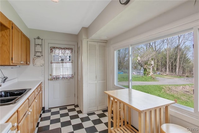 kitchen with light countertops, tile patterned floors, and a sink