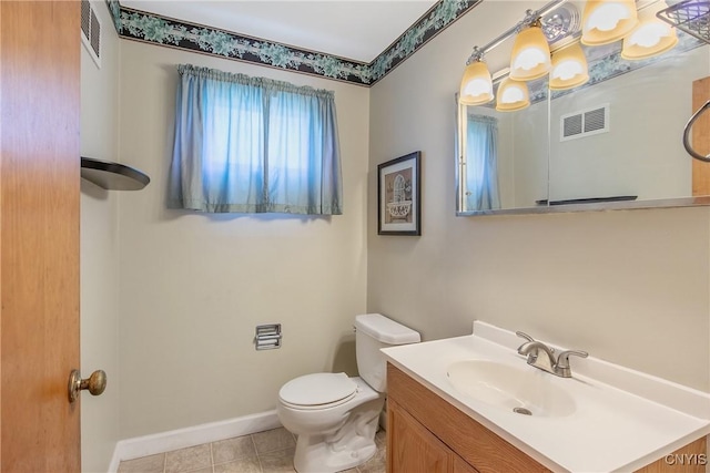 bathroom featuring vanity, toilet, tile patterned floors, baseboards, and visible vents