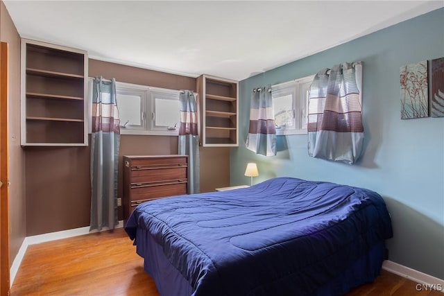 bedroom featuring baseboards and light wood finished floors