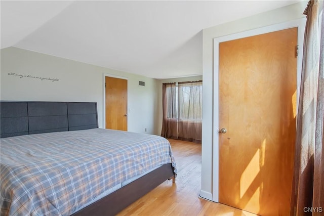 bedroom featuring light wood-style floors and visible vents