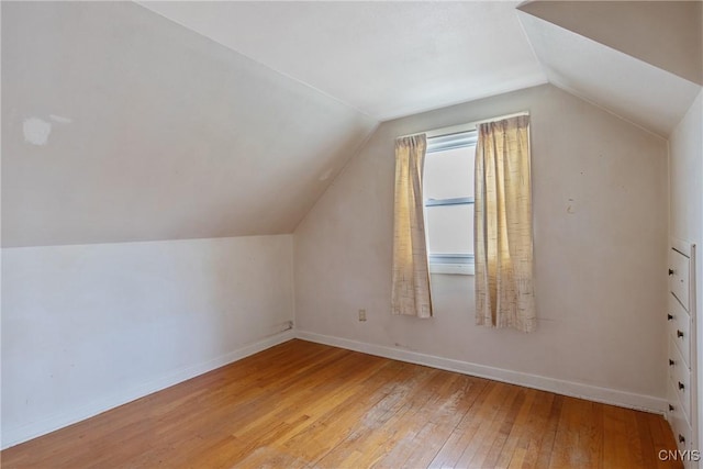 bonus room featuring baseboards, vaulted ceiling, and hardwood / wood-style floors