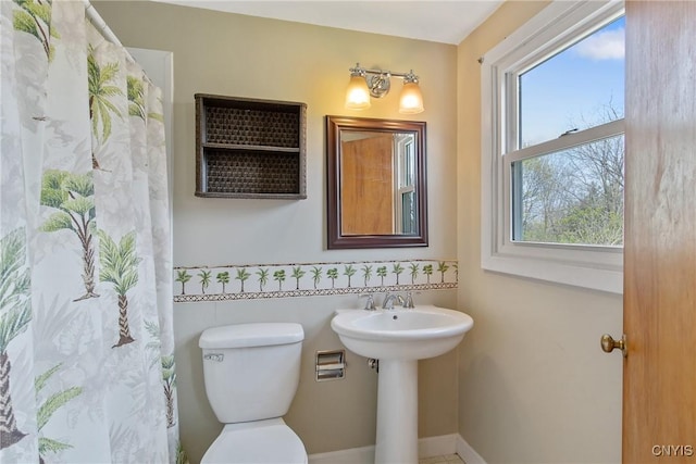 bathroom featuring toilet and a shower with curtain