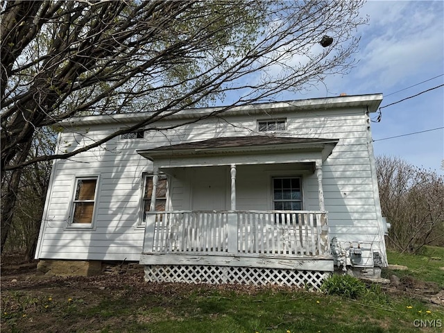 rear view of property featuring covered porch