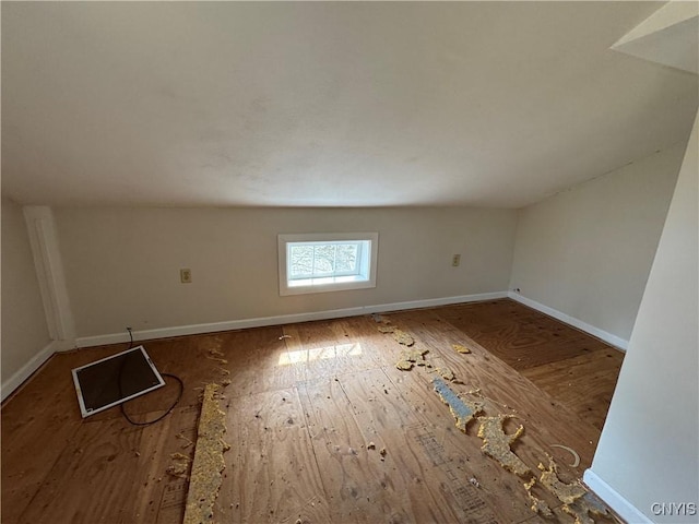 unfurnished room with baseboards and wood finished floors