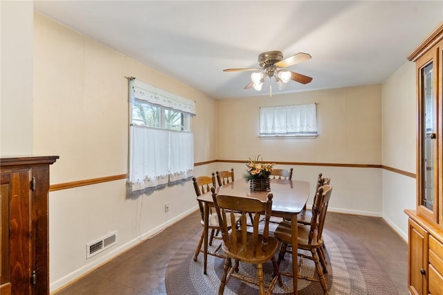 dining room featuring a ceiling fan, baseboards, visible vents, and dark carpet