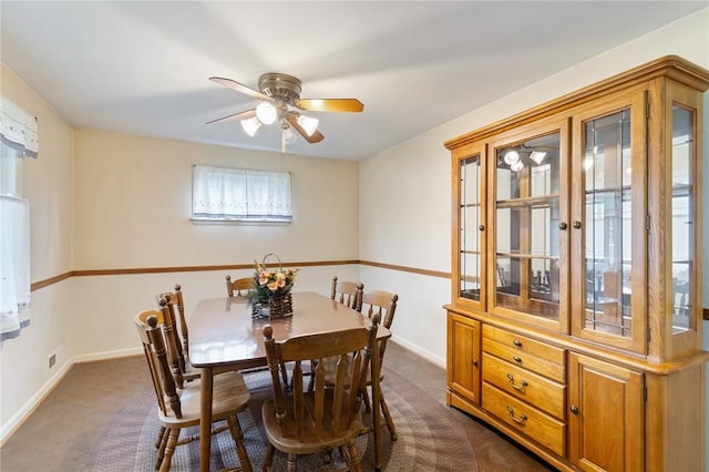 dining area featuring dark colored carpet, a ceiling fan, and baseboards