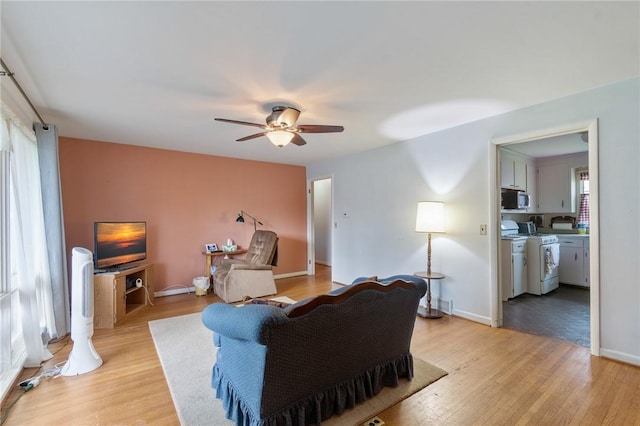 living room with a ceiling fan and light wood finished floors
