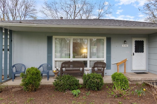 doorway to property featuring roof with shingles