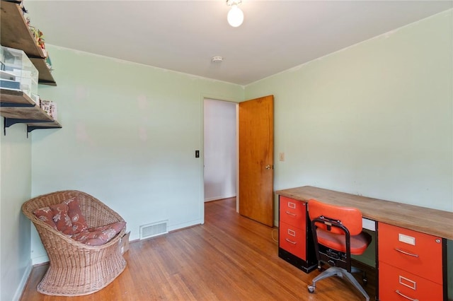 office featuring baseboards, visible vents, and wood finished floors