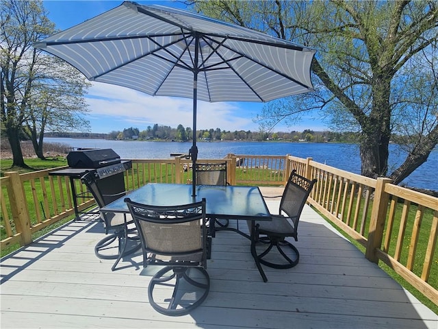 wooden terrace with grilling area, a water view, and outdoor dining area