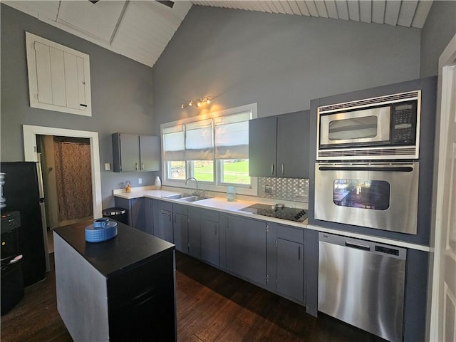 kitchen with a sink, gray cabinets, dark wood-style flooring, and stainless steel appliances