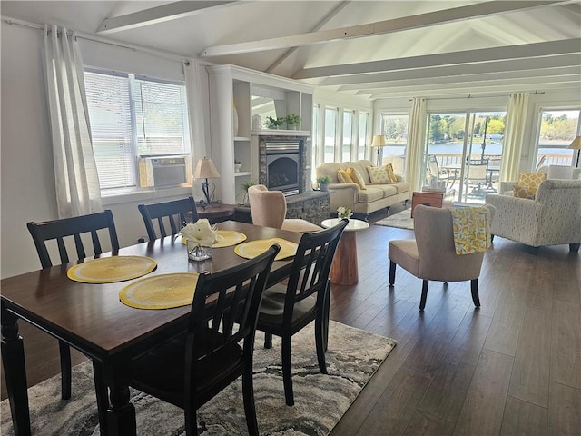 dining area featuring a healthy amount of sunlight, cooling unit, dark wood-style floors, and a stone fireplace