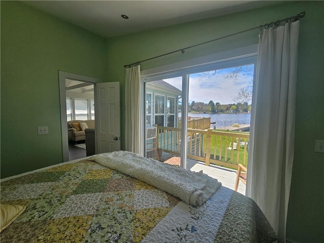 bedroom with a water view and access to exterior