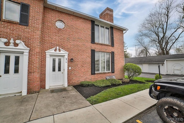 view of front of house featuring brick siding and a chimney