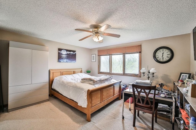 bedroom featuring light carpet, a ceiling fan, and a textured ceiling