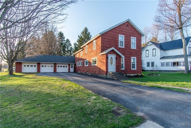 traditional home with a detached garage, an outdoor structure, and a front yard