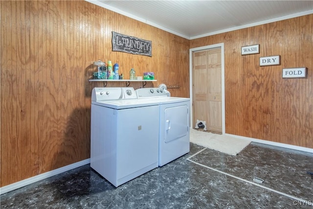 washroom with washer and dryer, wooden walls, laundry area, crown molding, and baseboards