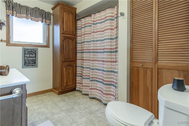 full bath featuring a shower with curtain, vanity, baseboards, a closet, and toilet