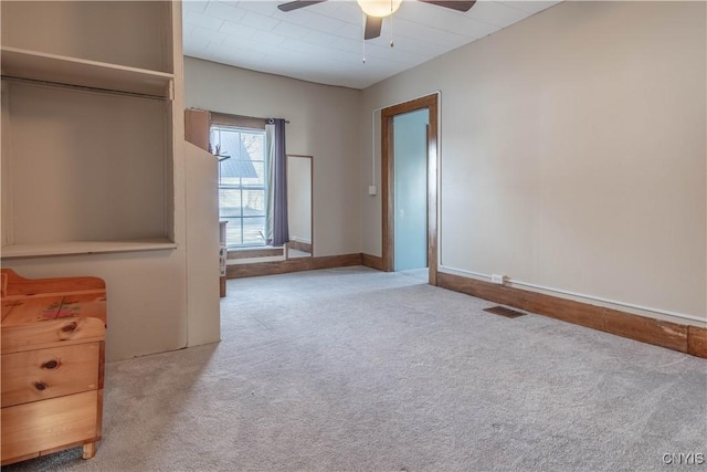 unfurnished bedroom featuring baseboards, carpet, ceiling fan, and visible vents