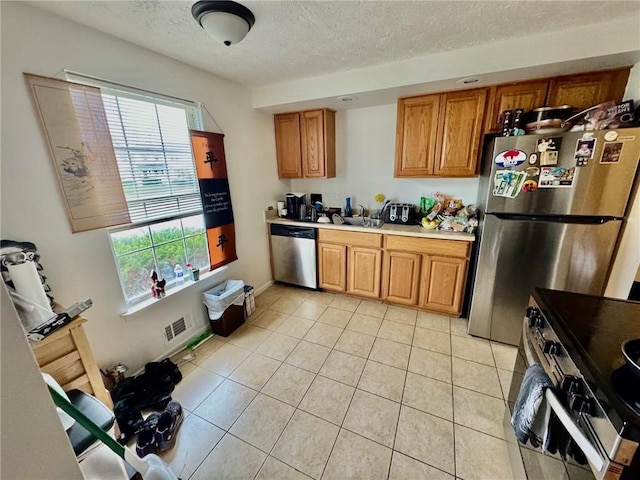 kitchen with brown cabinets, appliances with stainless steel finishes, plenty of natural light, and visible vents