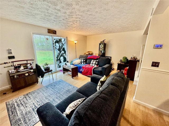 living room featuring baseboards, a textured ceiling, and wood finished floors
