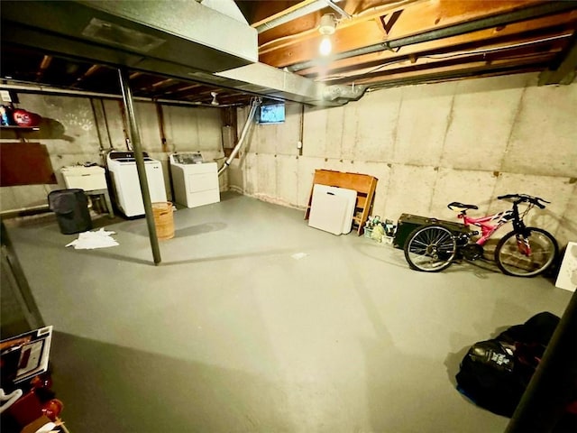 unfinished below grade area with washing machine and clothes dryer