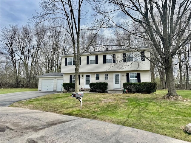 colonial-style house with a garage, a front lawn, and aphalt driveway